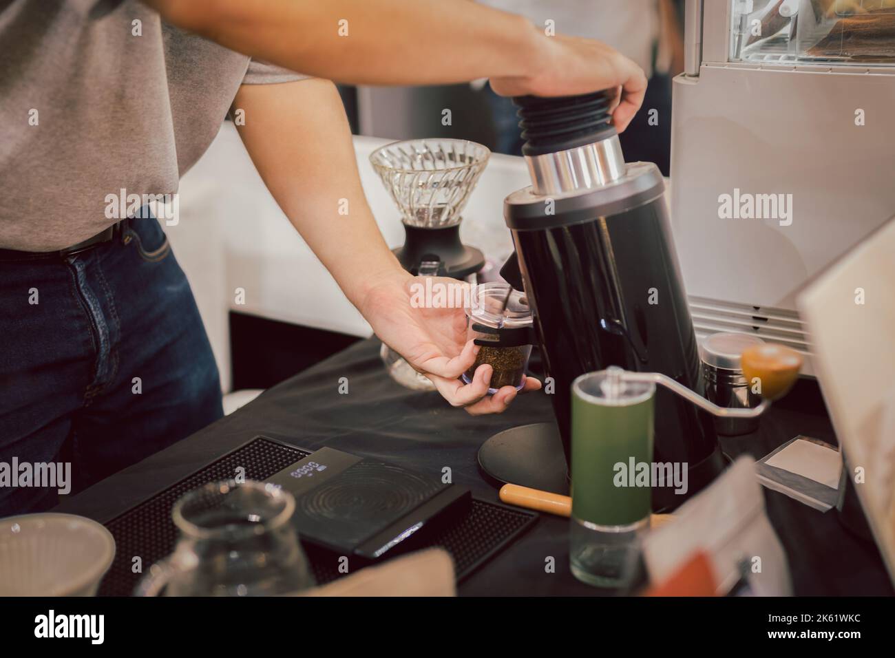 Barista mahlen Kaffeebohnen im Café. Stockfoto
