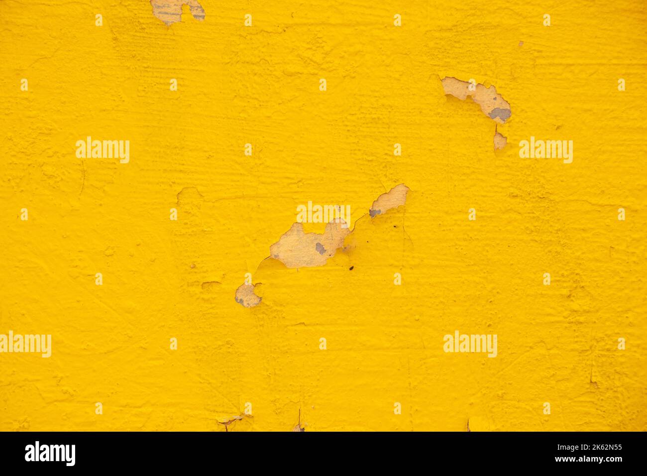Fassade einer Hauswand mit gelber geschälter Farbe als Hintergrund, einer Wand mit gelber Farbe Stockfoto
