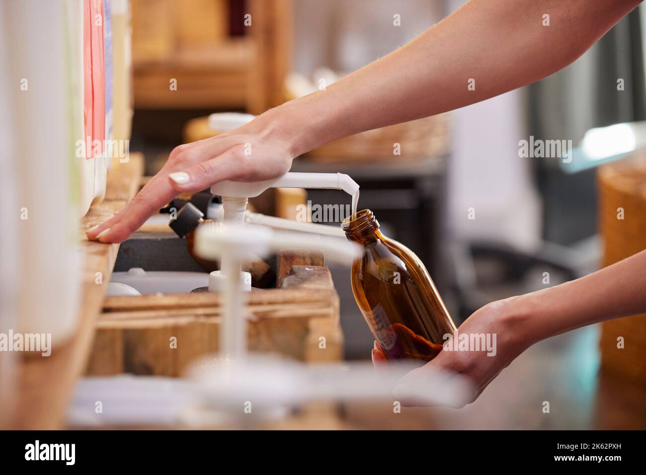 Nahaufnahme Einer Frau, Die Glasflasche Mit Flüssigseife Im Nachhaltigen Zero Waste Plastic Free Store Nachfüllt Stockfoto