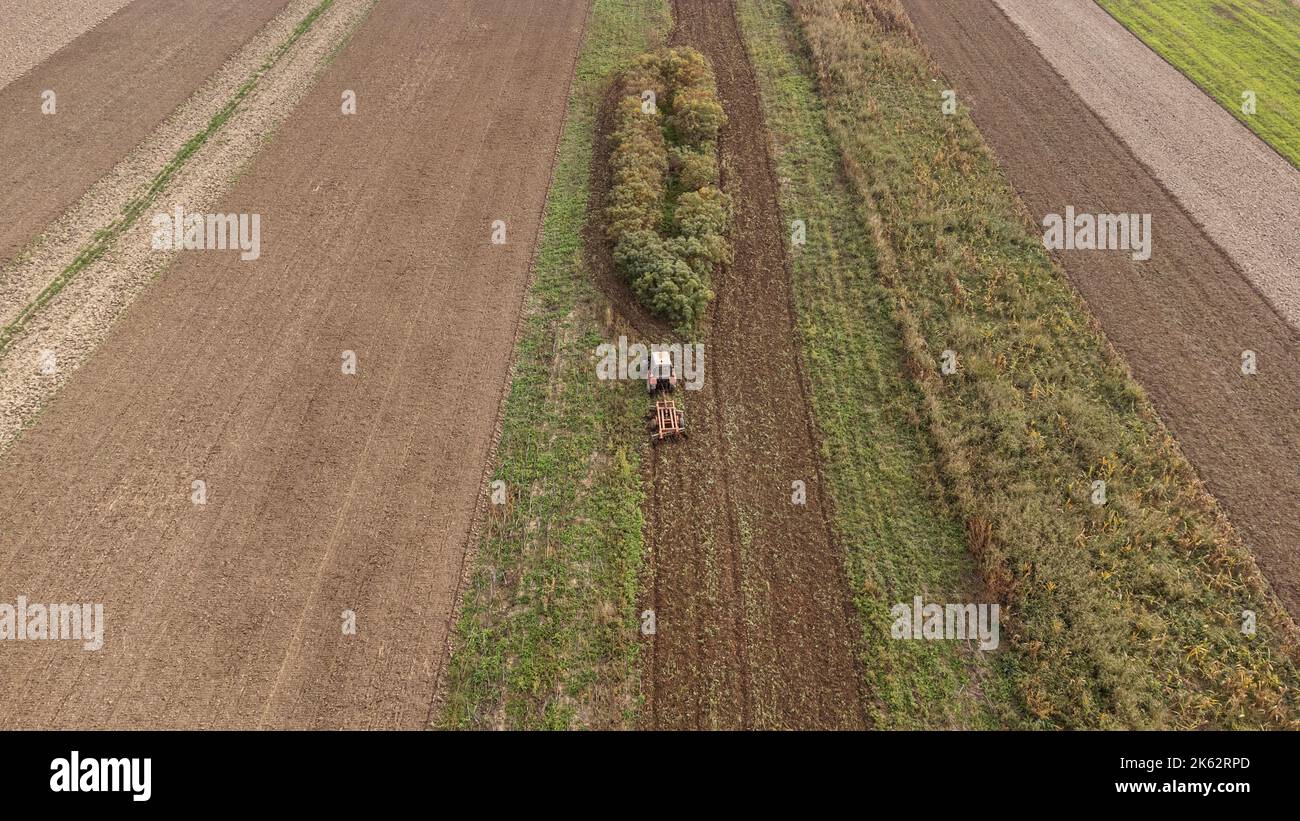 Traktor arbeitet auf dem Feld. Foto von der Drohne. Stockfoto