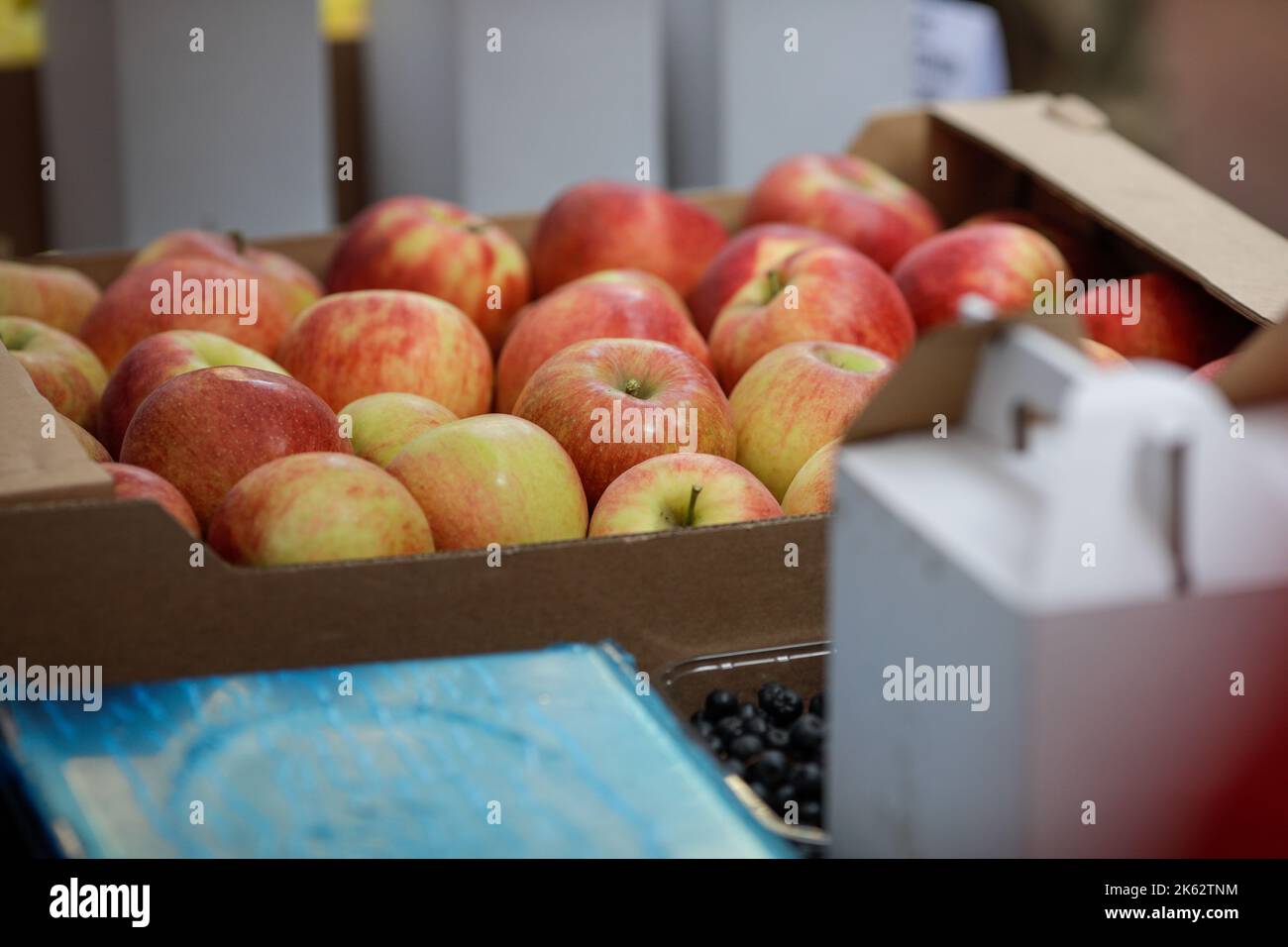 Details zur geringen Schärfentiefe (selektiver Fokus) mit roten Äpfeln in einem europäischen Bauernmarkt. Stockfoto