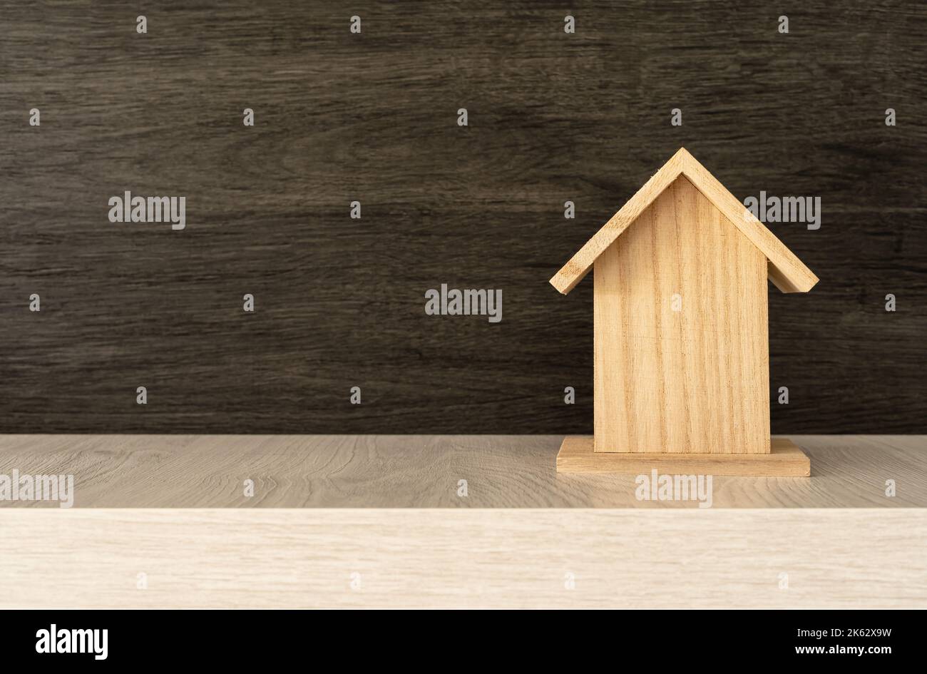 Hotelkonzept. Kleines Holzhaus aus dem jahr 3D auf schwarzem Holzgrund mit Platz auf der linken Seite. Stockfoto