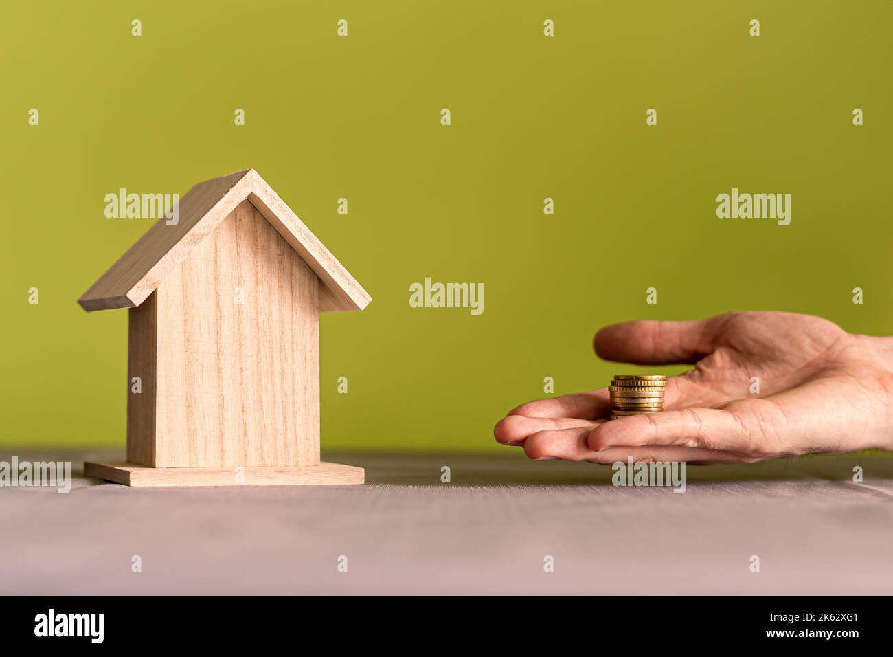 Hand einer Person, die spart, um den Kauf eines Hauses zu erwerben. Immobilienmarktkonzept. Stockfoto