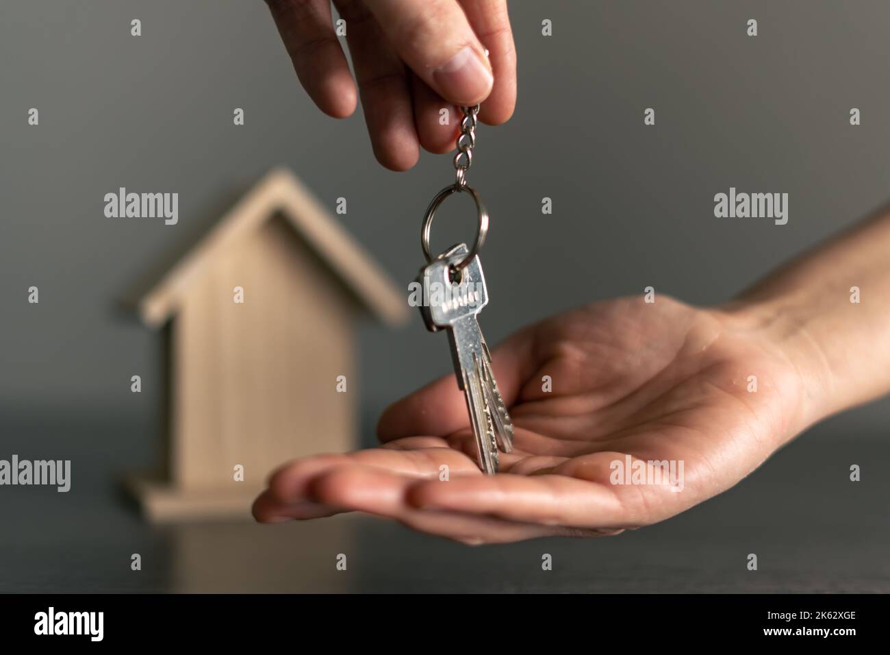 Die Hand der Frau, die die Schlüssel ihres neuen Hauses erhält, das im Besitz oder gemietet ist. Stockfoto