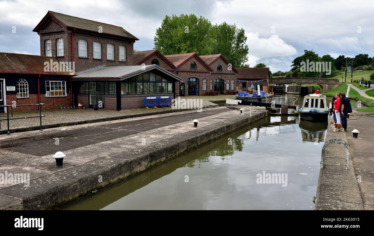 Besucherzentrum und Boot, die durch Schleusentore auf dem Weg nach dem Flug von 21 Schleusen an Hatton Schleusen auf dem Grand Union Canal, Warwick, Warwickshire, fahren Stockfoto