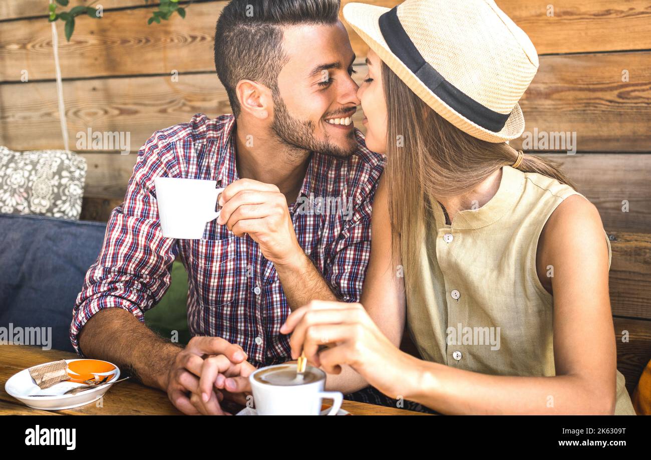 Junge Modeliebhaber pärchen zu Beginn der Liebesgeschichte - hübscher Mann küsst schöne Frau an der Café-Bar - Beziehungskonzept mit glücklichem Jungen Stockfoto