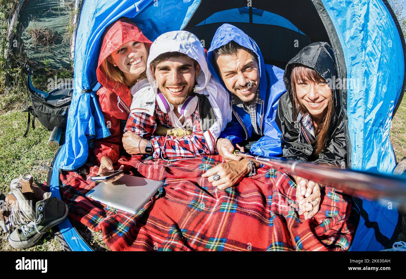Beste Freunde Paare, die am sonnigen Tag nach dem Regen Selfie im Campingzelt machen - Jugend- und Freiheitskonzept im Freien in den Frühlingsferien - Junge p Stockfoto