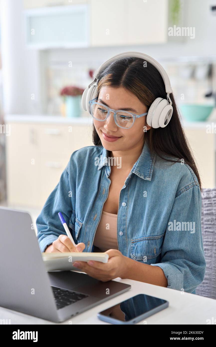 Junger asiatischer Student, der online studiert, sieht sich das Webinar zum Thema Bildung auf einem Laptop an Stockfoto