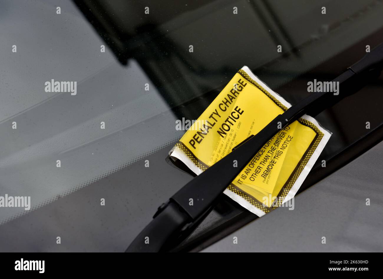 Parkschein, Hinweis zu Strafgebühren, an der Windschutzscheibe des Fahrzeugs, Großbritannien Stockfoto