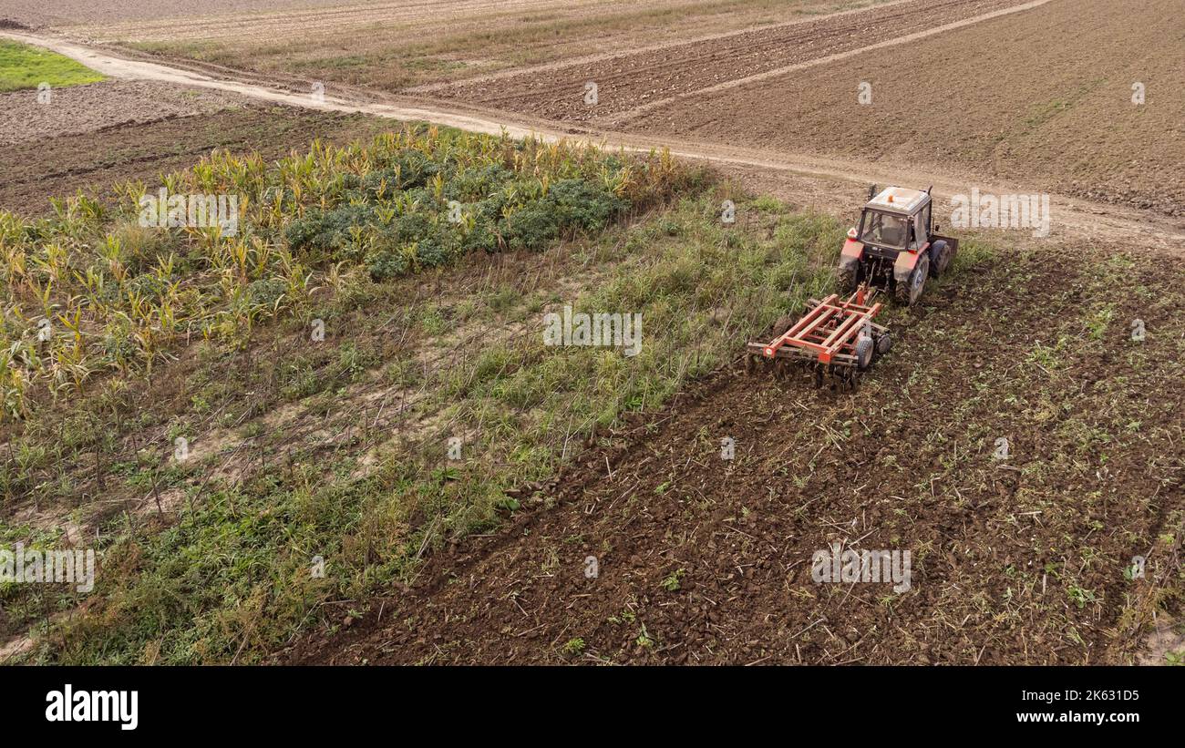 Traktor arbeitet auf dem Feld. Foto von der Drohne. Stockfoto
