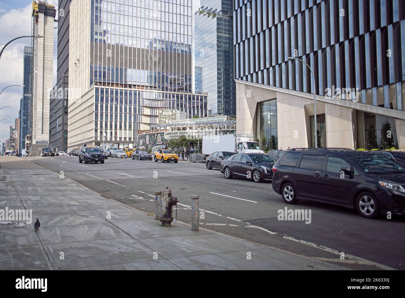 New York, NY, USA - 11. Okt 2022: Seitenansicht der Türme auf den Hudson Yards und des Verkehrs auf der 11. Ave an einem teilweise bewölkten Herbsttag. Stockfoto