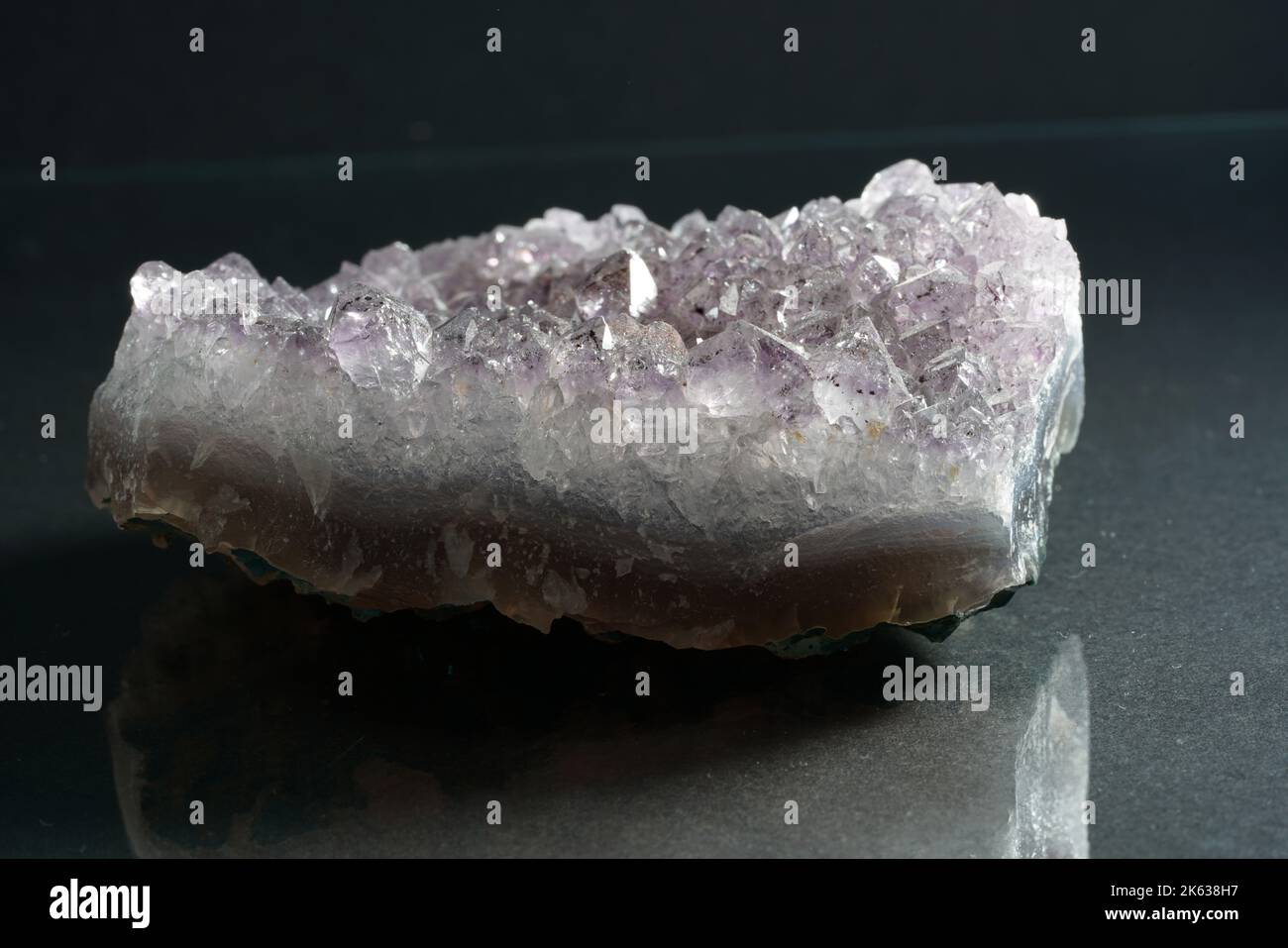 Eine Nahaufnahme eines schönen Amethyst-Steins, isoliert auf einem grauen Hintergrund Stockfoto