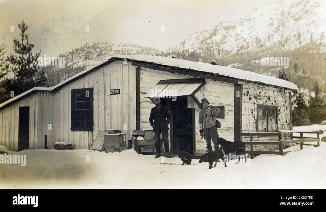 British Columbia, Kanada – (möglicherweise Grand Forks?) Das Postamt mit zwei Männern und Hunden - ca. 1912. Stockfoto
