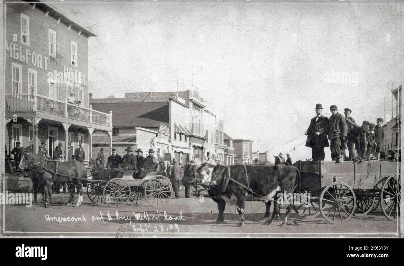Melfort, Saskatchewan, Kanada - Eine Gruppe von Amerikanern, die Land kaufen wollen - September 28. 1909. Geschäftige Straßenszene mit feinem Bullock Cart (rechts). Stockfoto
