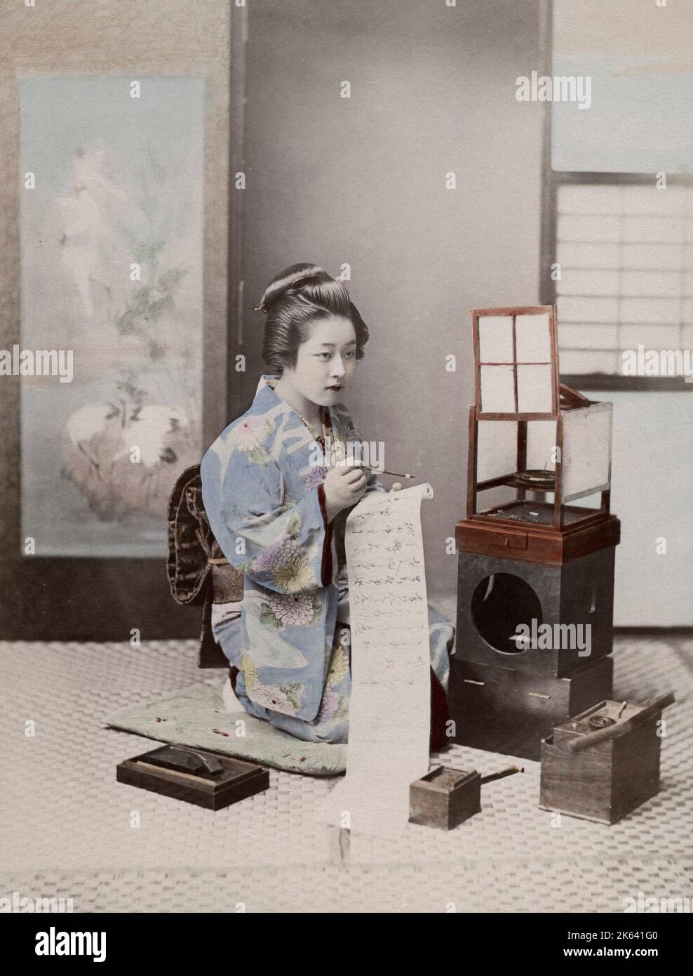 Japanische Geisha in einem verzierten Kimono, die einen Brief schreibt. Vintage 19. Jahrhundert Foto. Stockfoto
