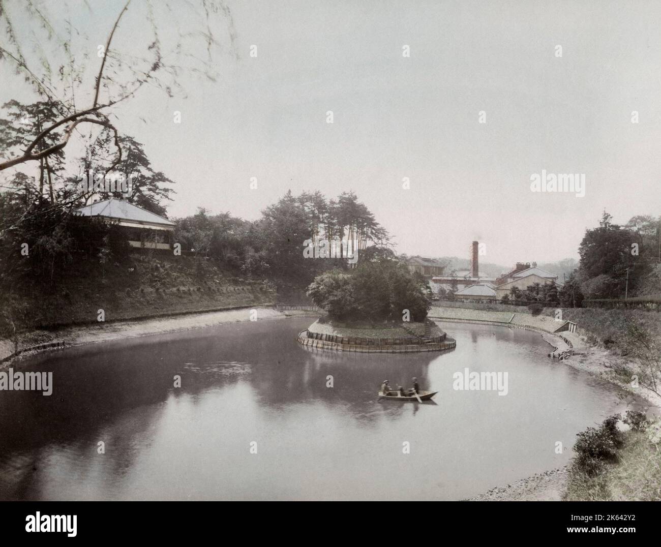 Kleines Boot auf einem See mit Fabrik im Hintergrund, wahrscheinlich Yokohama, Japan, Ende des 19.. Jahrhunderts. Stockfoto