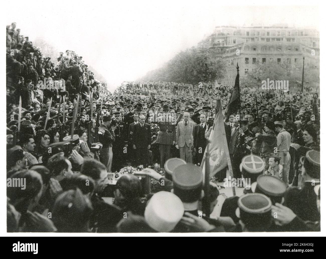 WW2 Uhr - nach der Bekanntgabe des Sieges wird General de Gaulle von der Menge gefeiert und salutiert das Grab des unbekannten Soldaten. Stockfoto