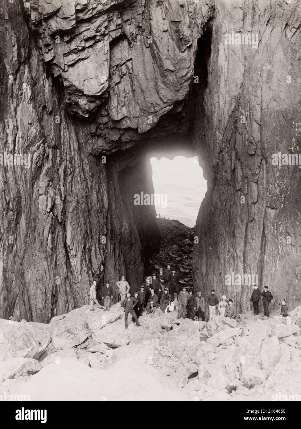 Oldtimer-Foto aus dem 19. Jahrhundert: Torghatten ist ein Granitberg auf der Insel Torget in der Gemeinde Bronnoy im Nordland County, Norwegen. Sie ist für ihre charakteristische Bohrung bekannt. Touristengruppe. Stockfoto