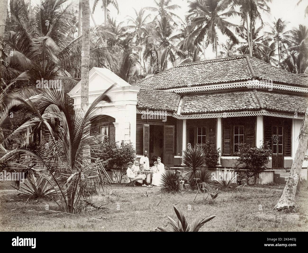 Vintage 19. Jahrhundert Foto - Europäische Familie außerhalb ihrer kolonialen Bungalow, mit einem Diener, Singapur oder Südost-asiatischen Ort. Stockfoto