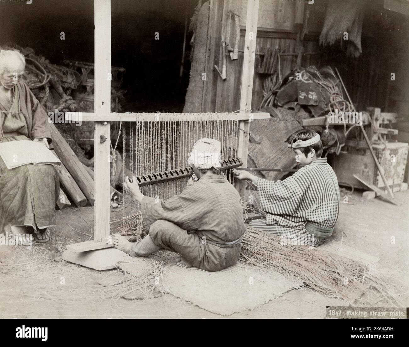 Vintage-Fotografie des 19. Jahrhunderts - Japanische Männer weben Strohmatten auf einem Webstuhl, Japan, um 1880. Stockfoto