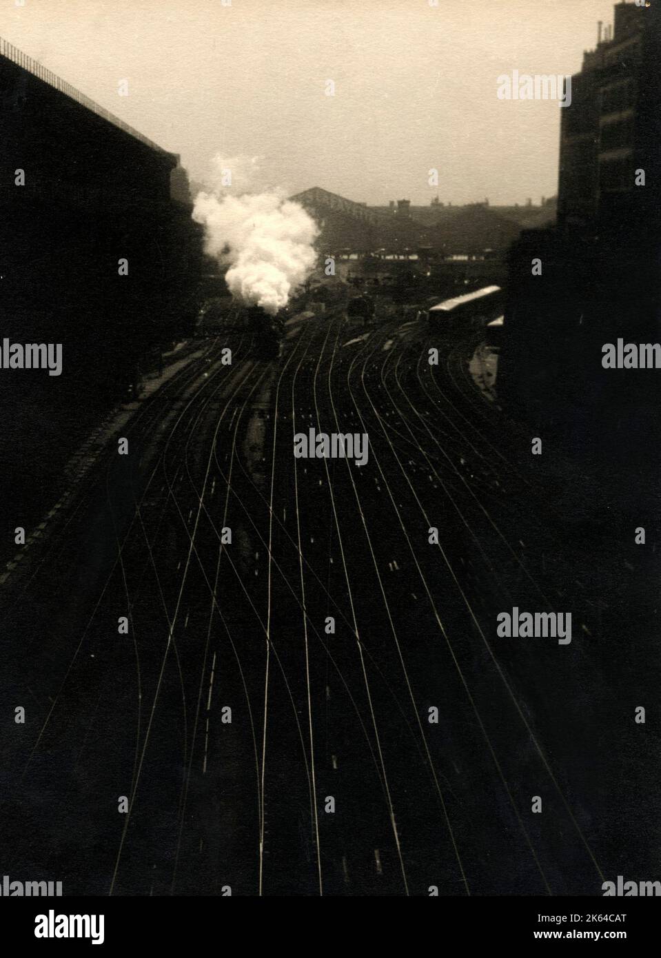 Atmosphärische Schuß eines stream Zug Lokomotive Verlassen eines britischen Bahnhof c 1930. Stockfoto