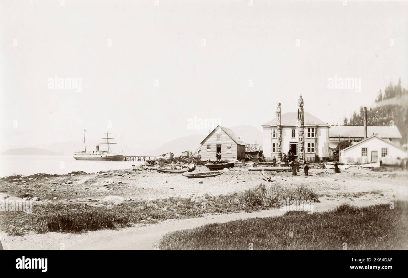 Jahrgang c,1900 Foto: Gebäude und Totempfähle am Wasser, Alaska. Stockfoto