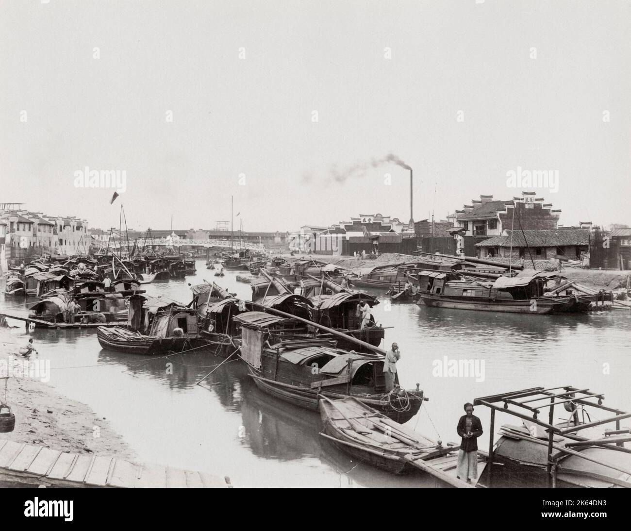 19th Jahrhundert Vintage-Foto: Fluss voller kleiner Boote, Fabrikschornstein im Hintergrund, geschäftige Stadtszene, Asien. Stockfoto