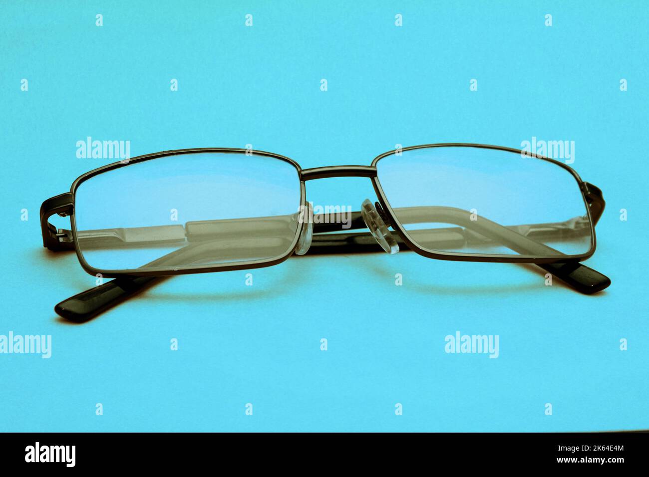 Brille in schwarzem Rahmen auf blauem Hintergrund mit Kopierraum. Welttag des Sehens. Stockfoto