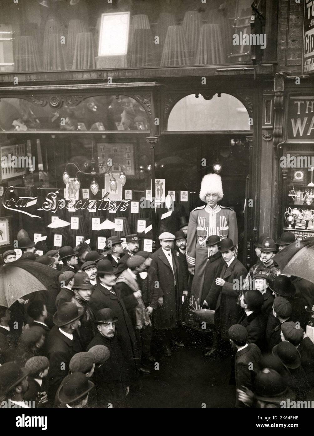 Vintage-Pressefoto aus dem frühen 20.. Jahrhundert - Feodor Machnow, der berühmte russische Riese, kommt nach London, um im Hippodrme 1905 aufzutreten. Machnow besuchte einen Schneider, wo er für einen neuen Mantel gerüstet wurde. Stockfoto