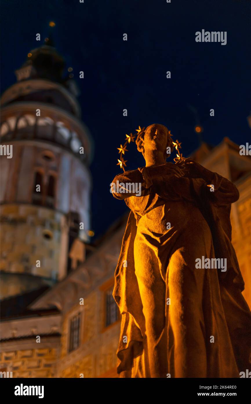 Statue des heiligen mit dem Turm der Burg Cesky Krumlov im Hintergrund. Nachtfoto. Cesky Krumlov, Südböhmen, Tschechische Republik. Stockfoto