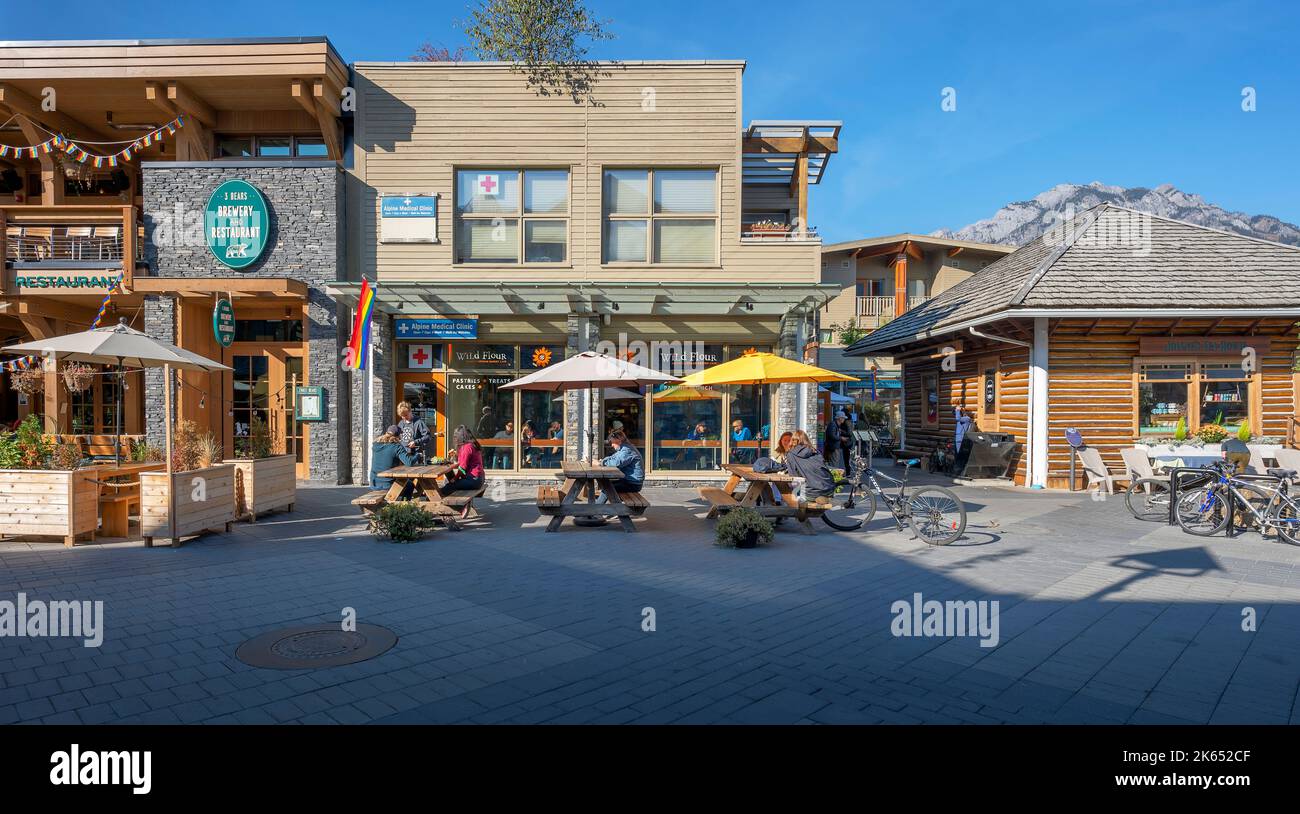 Banff, Alberta, Kanada – 07. Oktober 2022: Menschen sitzen an Picknicktischen vor einer Bäckerei in der Innenstadt Stockfoto