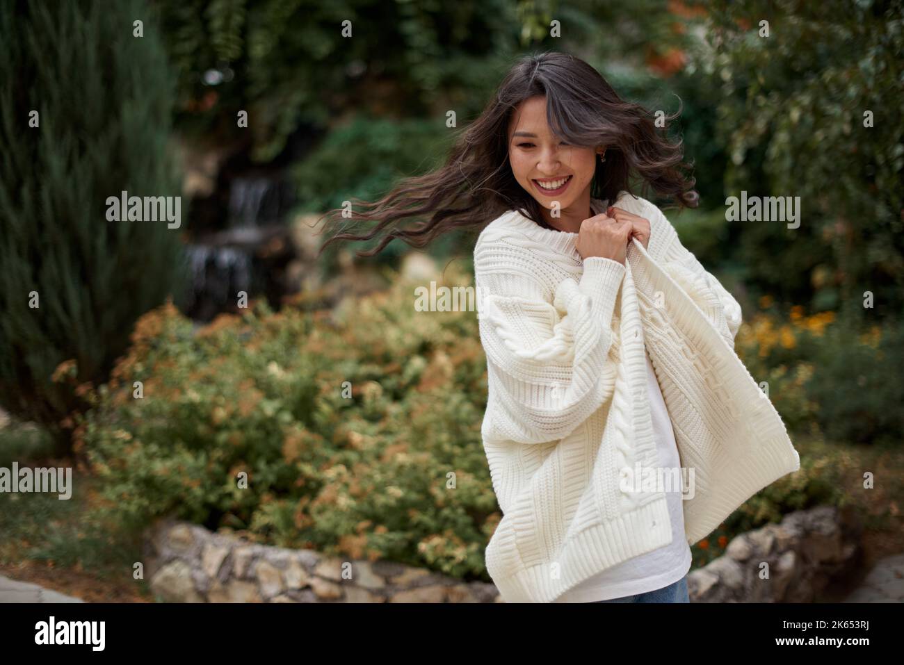 Schöne asiatische kasachische Brünette Frau mit fliegenden langen Haaren Stockfoto