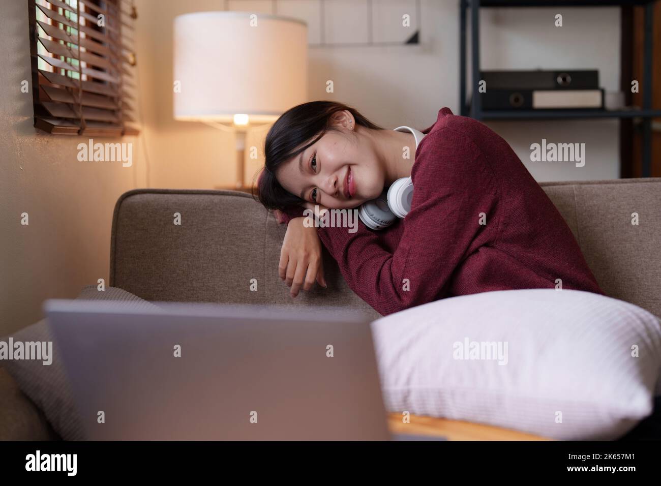 Junge asiatische Frau glückliches Leben sitzen auf Couch gemütliches Wohnzimmer zu Hause. Das Haus war ein gemütliches Konzept Stockfoto