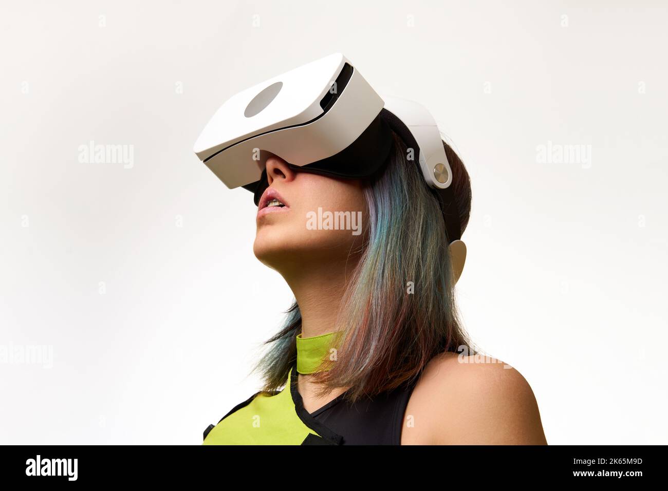 Frau verwendet ein Virtual-Reality-Headset. Konzept der virtuellen, erweiterten und erweiterten Realität, Metaverse, Unterhaltung und Kommunikation. Stockfoto