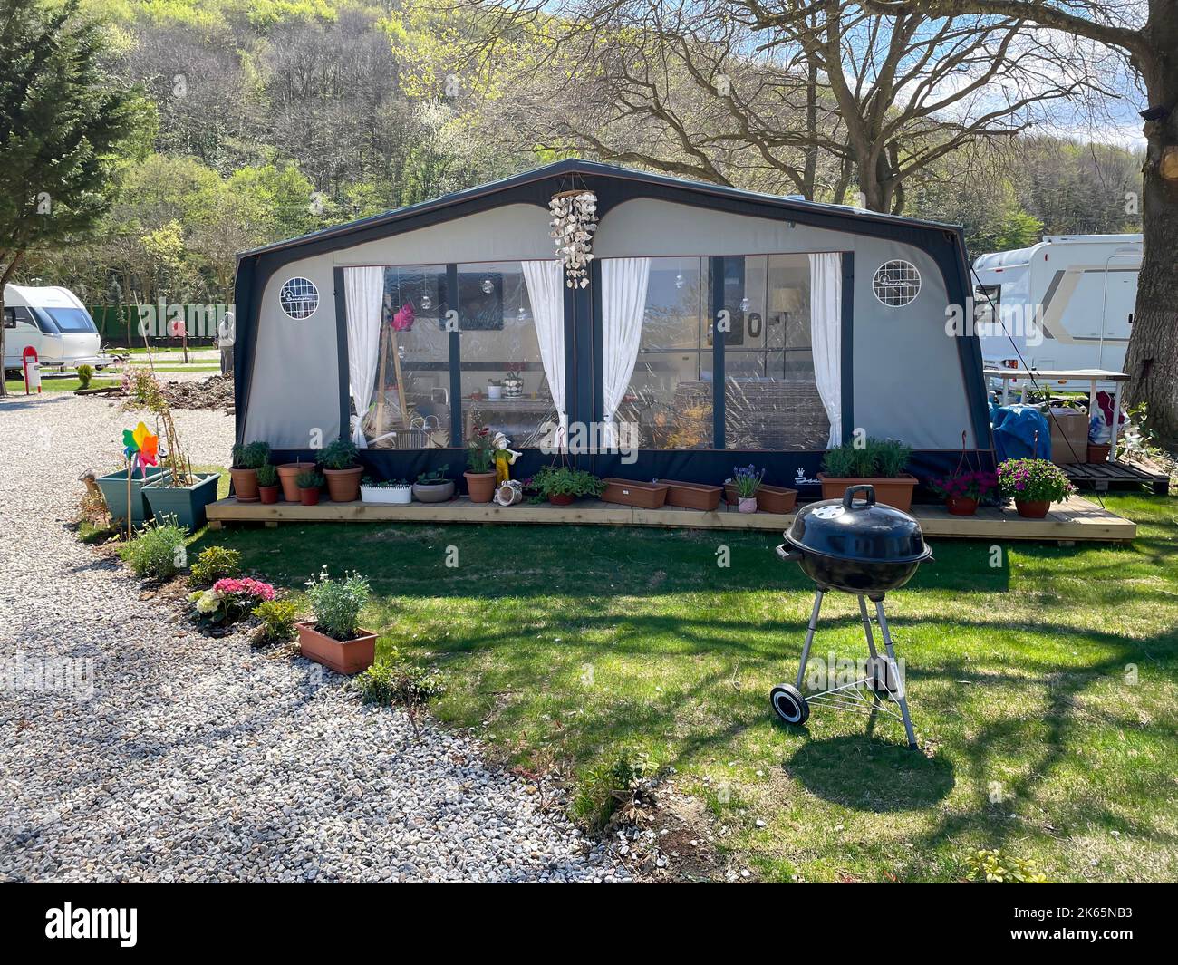 Ein offenes Zelt vor einem Reiseanhänger auf einem Caravan-Campingplatz. Caravan Camping Konzept. Riva, Istanbul, Türkei - 04. April 2022. Stockfoto