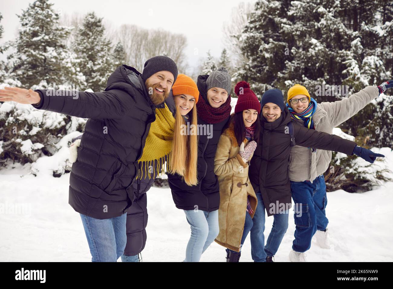Portrait einer Gruppe fröhlicher, lustiger junger Freunde, die sich für einen Winterspaziergang im Freien versammelt haben. Stockfoto
