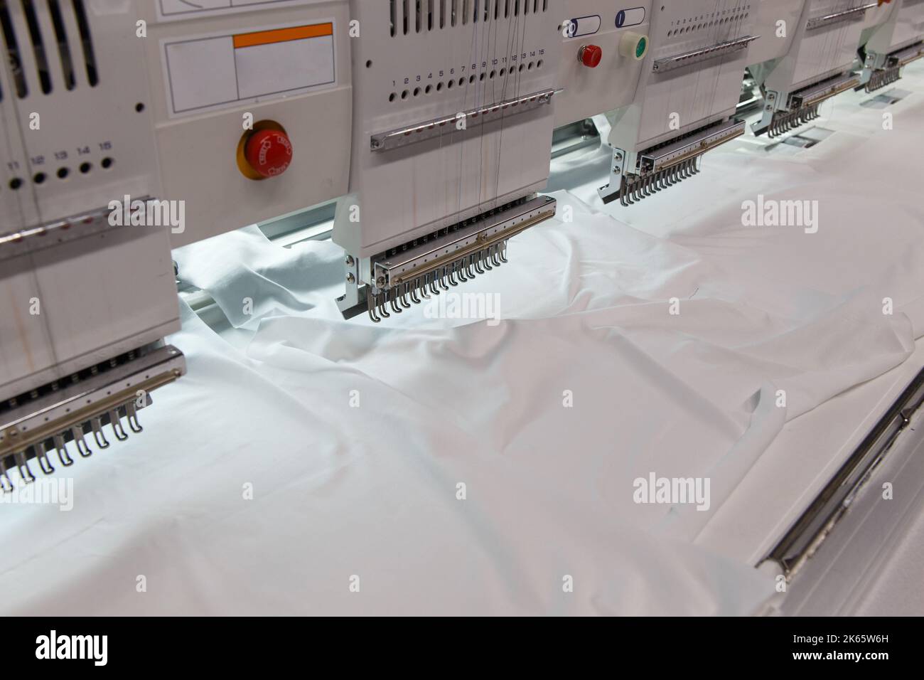 Maschinenstickerei ist ein Stickprozess, bei dem eine Nähmaschine oder Stickmaschine verwendet wird, um Muster auf Textilien zu erstellen. Textil: Industriell Stockfoto
