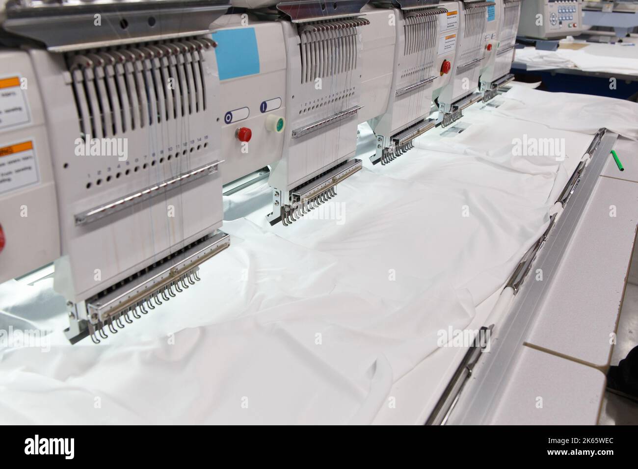 Maschinenstickerei ist ein Stickprozess, bei dem eine Nähmaschine oder Stickmaschine verwendet wird, um Muster auf Textilien zu erstellen. Textil: Industriell Stockfoto