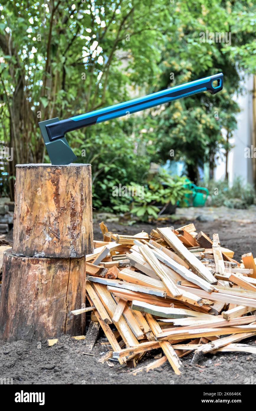 Axe auf Brennholz-Hackblock mit gehackten Holzstäben zum Anzünden und Anzünden von Feuern oder Heizöfen. Stockfoto
