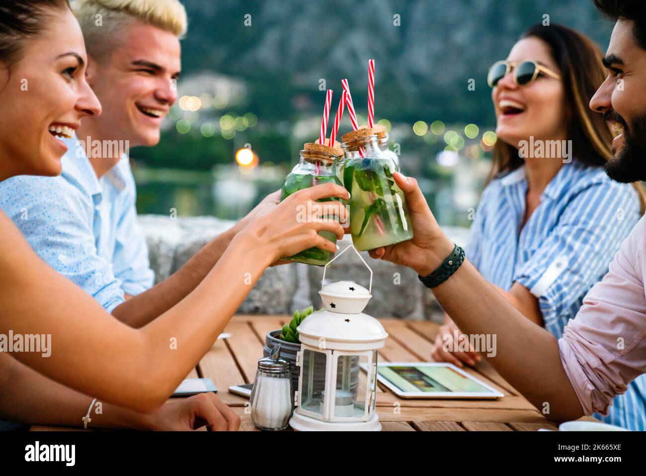 Urlaubsreisen Menschen und Essen Konzept. Glückliche Freunde, die bei der Sommerparty zu Abend essen Stockfoto