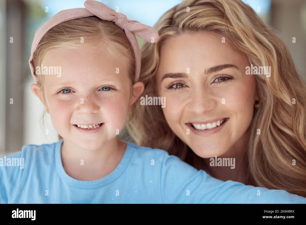 Entzückendes kleines Mädchen, das für Selfies lächelt, während es sich zu Hause mit ihrer Mutter verklebt. Fürsorgliche und liebevolle Mutter, die sich mit ihrer niedlichen Tochter entspannt. Einzeln Stockfoto