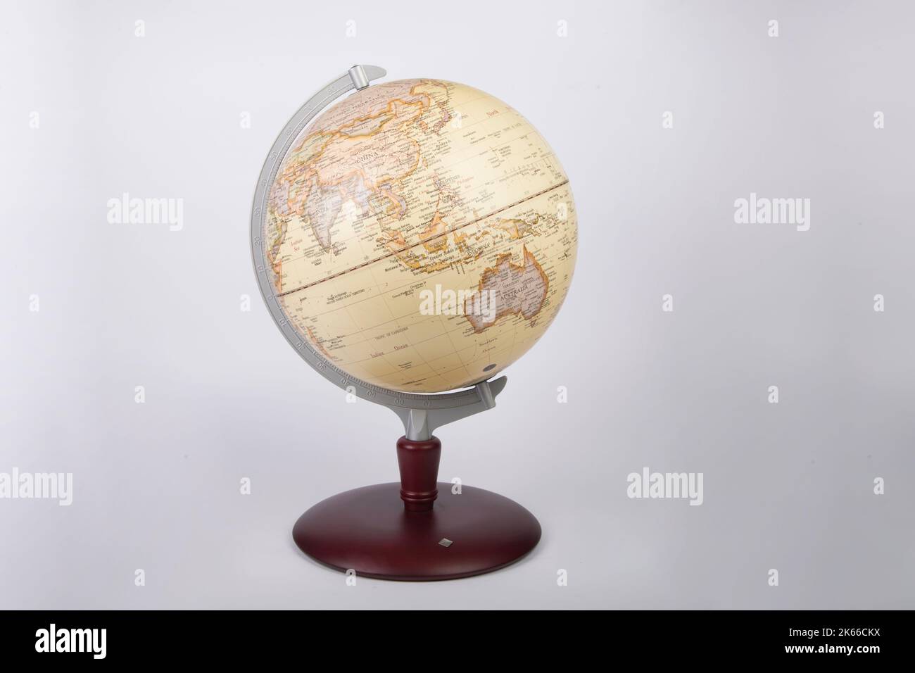 Ein gelber Welt-Atlas-Globus, isoliert auf grauem Hintergrund Stockfoto