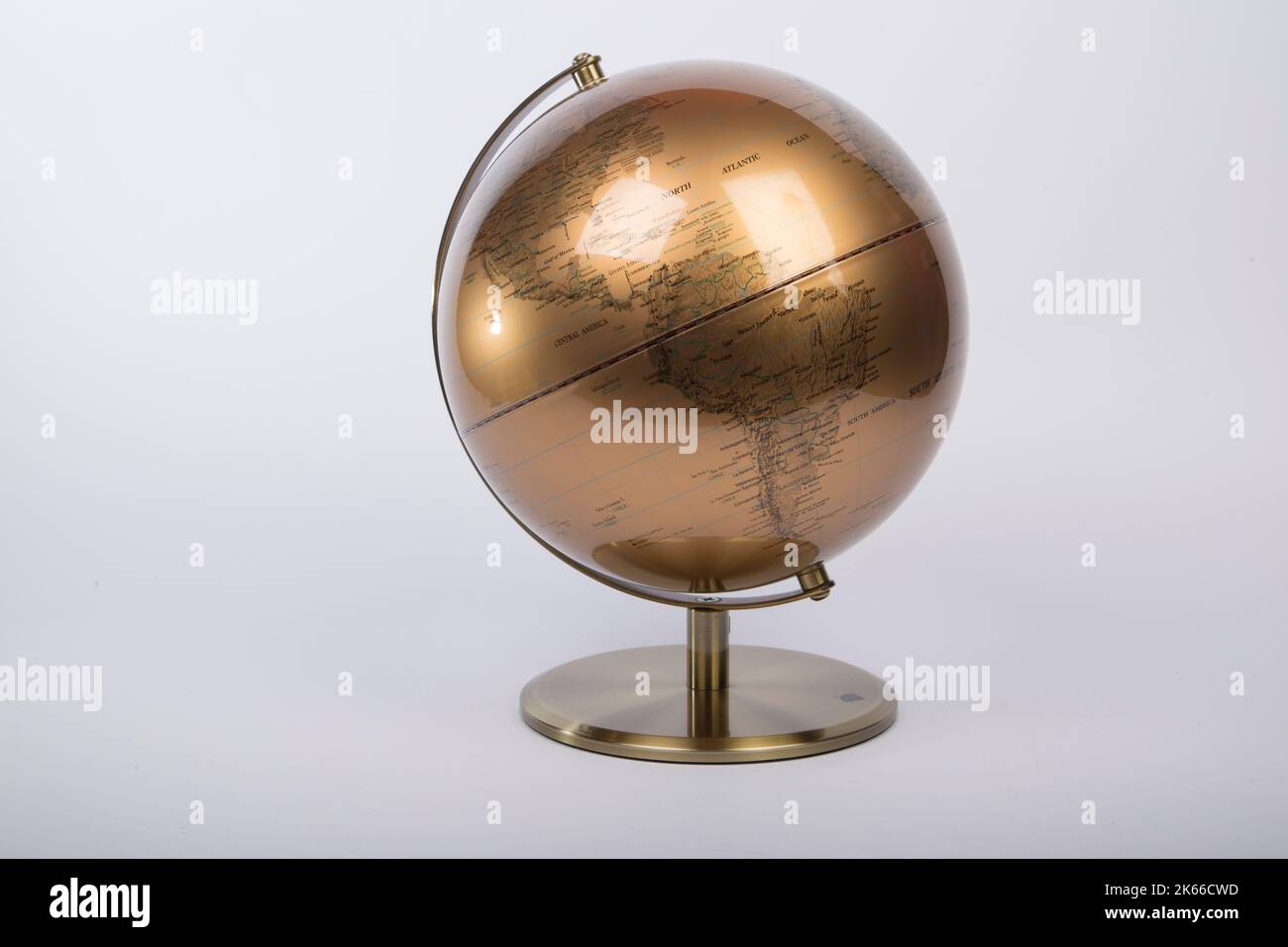 Ein goldener Welt-Atlas-Globus, isoliert auf grauem Hintergrund Stockfoto