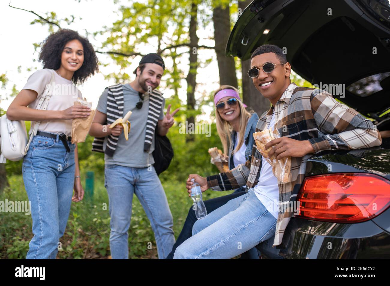 Freunde essen Sandwich im Freien und fühlen sich fröhlich Stockfoto
