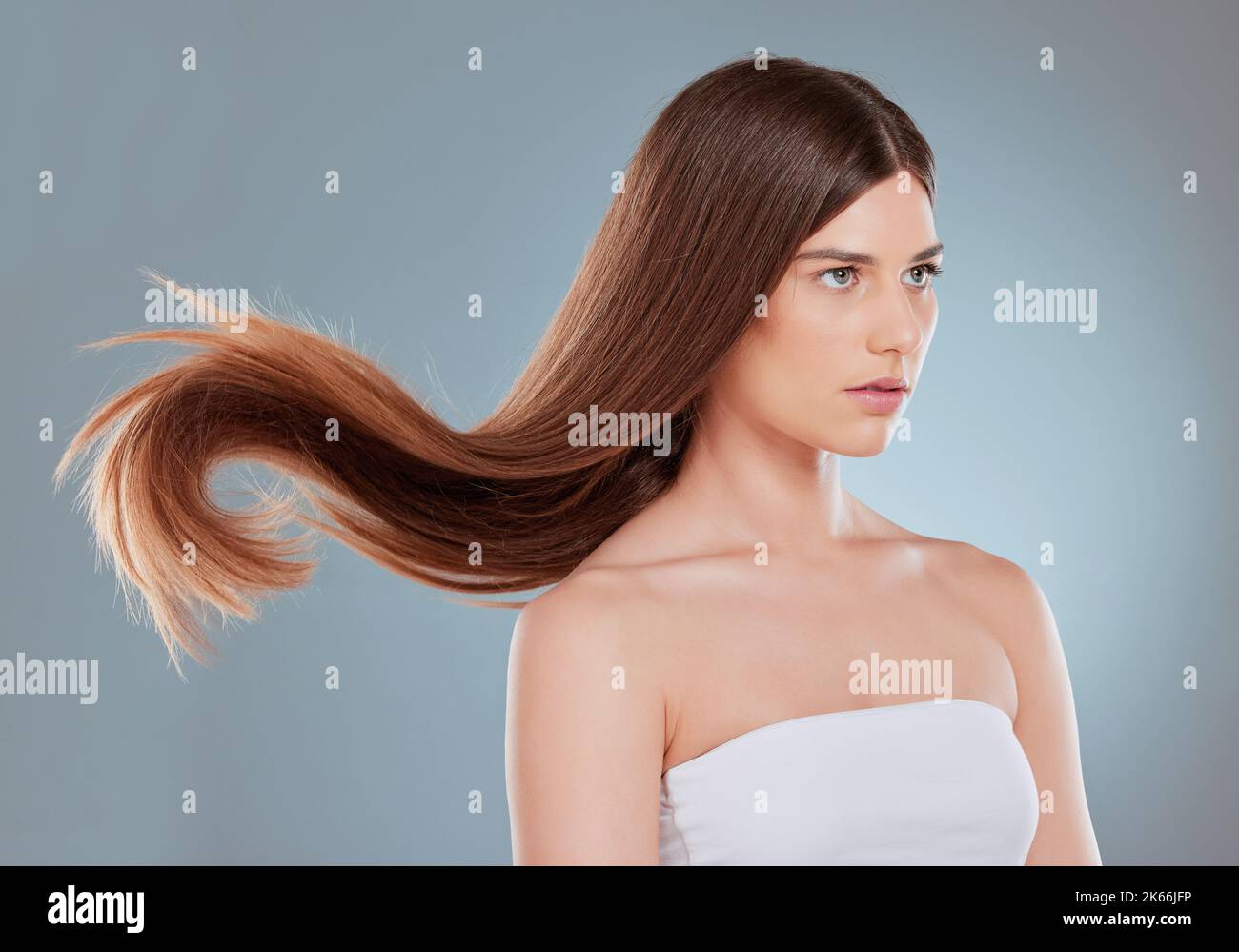 Es ist wichtig, ein Shampoo zu verwenden, das für Ihren Haartyp entwickelt wurde. Studioaufnahme einer schönen jungen Frau, die ihr langes braunes Haar zeigt. Stockfoto