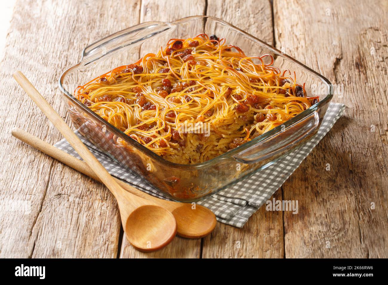 yerushalmi kugel ein traditionelles osteuropäisches jüdisches Essen aus Nudeln und verbranntem Zucker in einer Glasschüssel auf dem Tisch. Horizontal Stockfoto