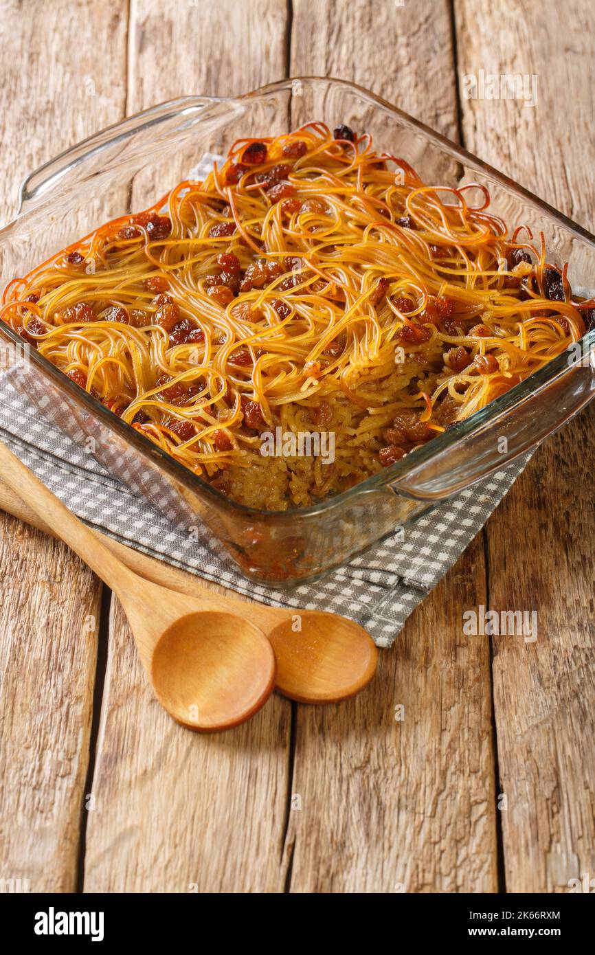 Kugel Yerushalmi, auch bekannt als Jerusalem kugel ist ein israelisches süßes Gericht mit Nudeln, Rosinen, Zimt und Zucker aus der Nähe in Glasform auf dem Tisch Stockfoto