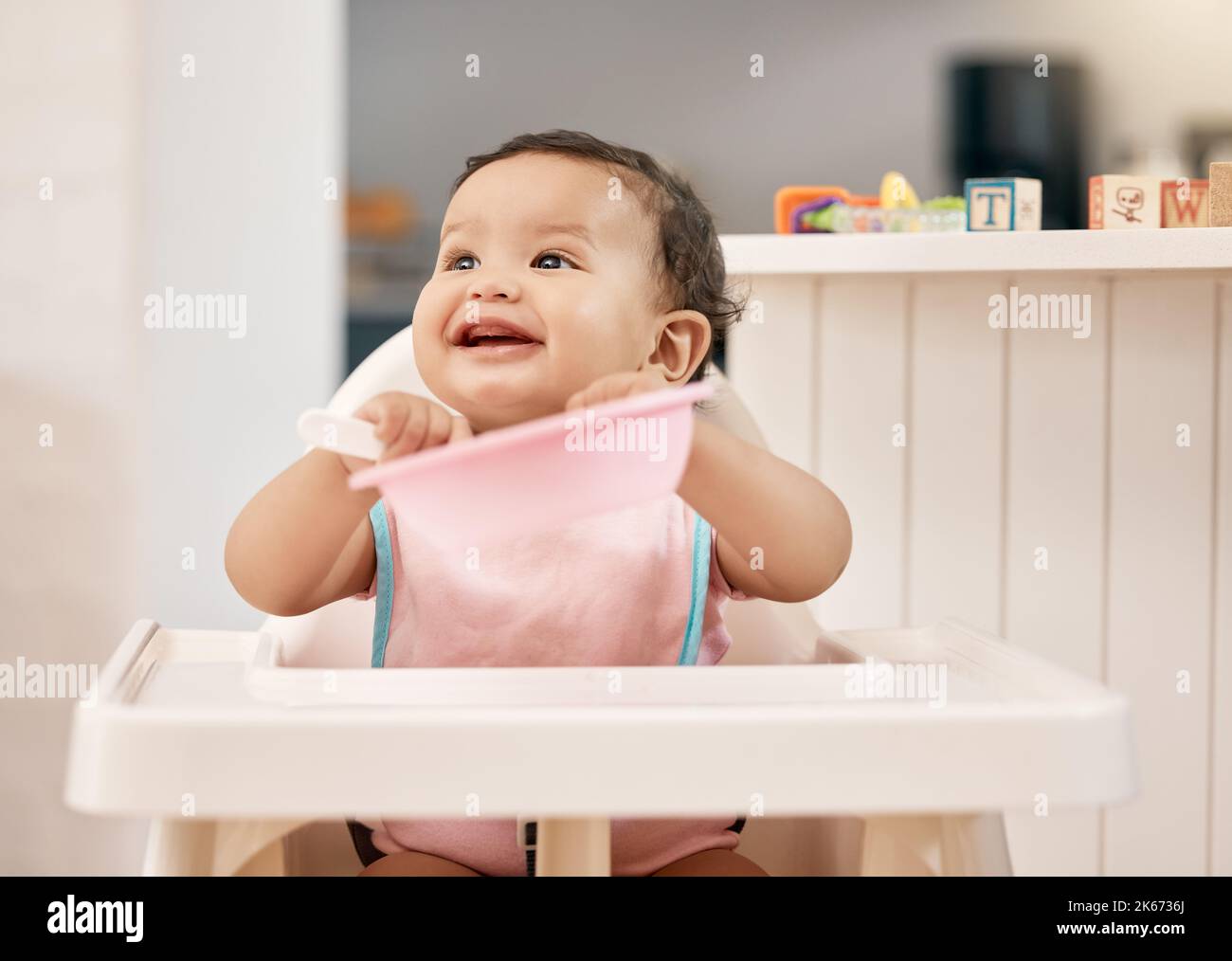 Kann ich eine Nachfüllung bekommen? Ein entzückendes Baby, das in ihrem Futterstuhl sitzt. Stockfoto
