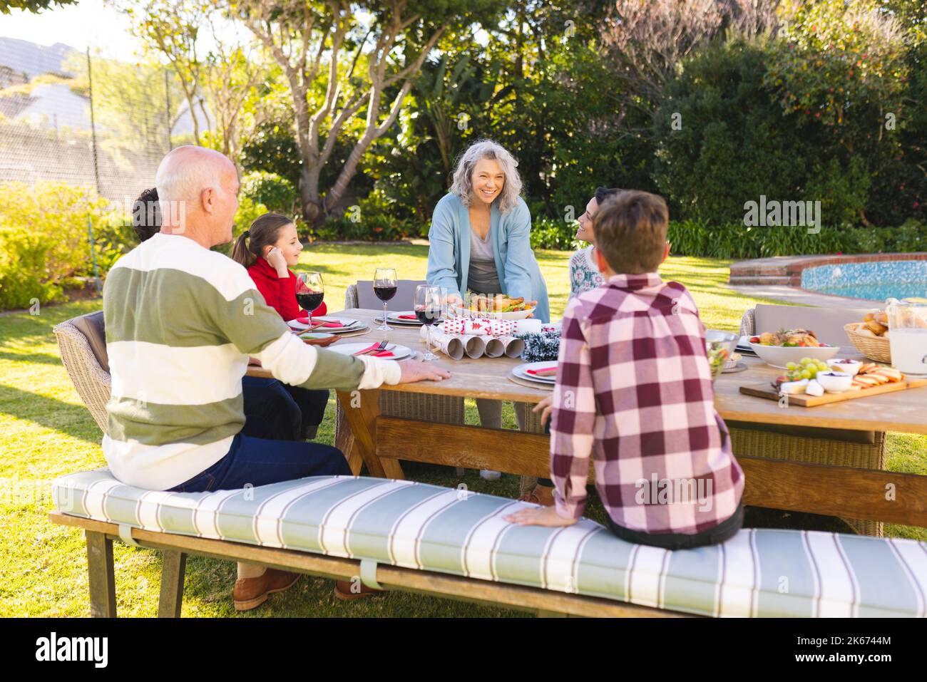 Glückliche weiße Familie, die Zeit miteinander verbringt und im Garten zu Abend isst Stockfoto