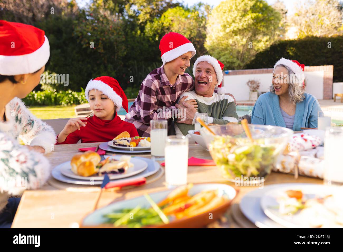 Die weiße Familie verbringt Zeit miteinander und hat einen weihnachtsbaum im Garten Stockfoto